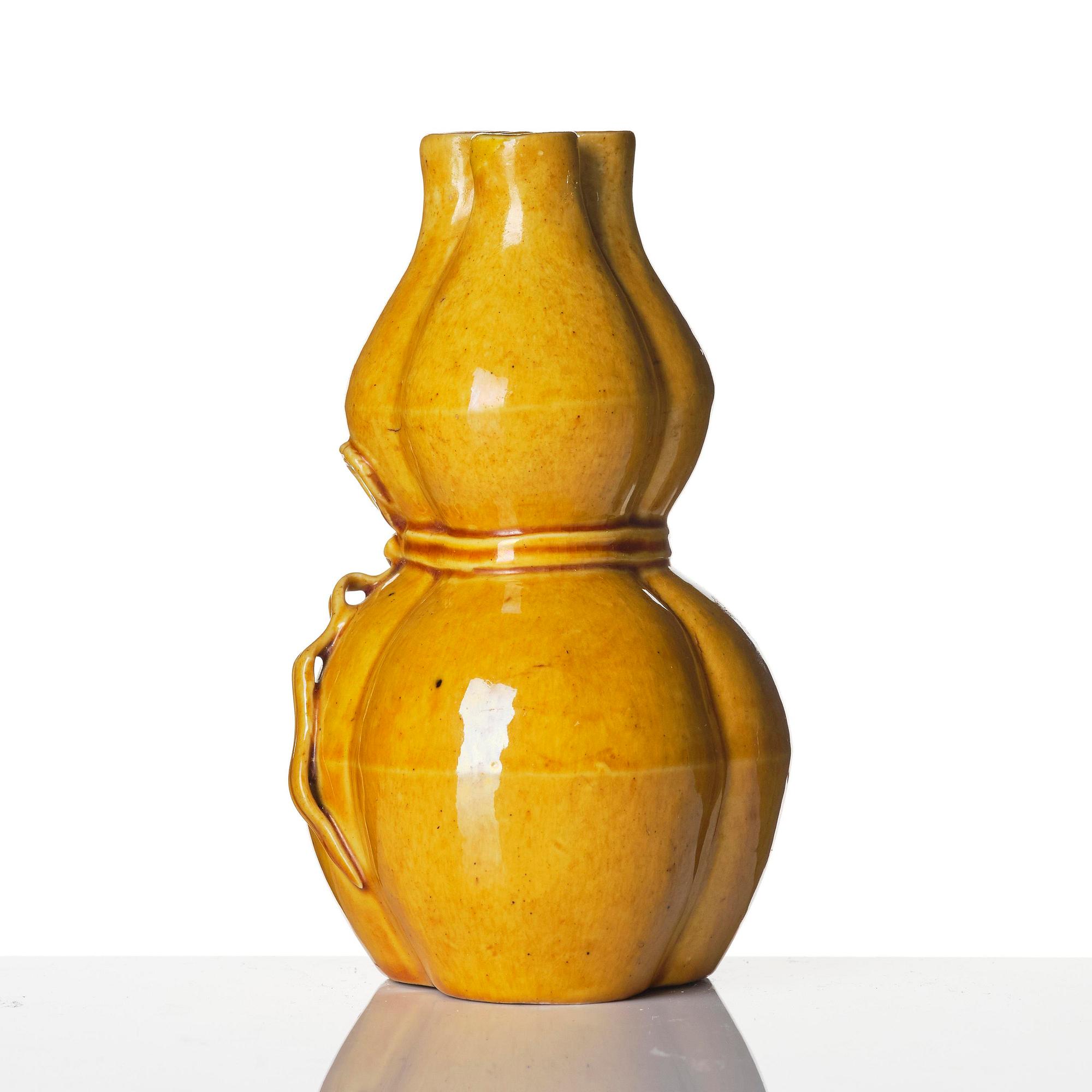 A yellow glazed triple spouted double gourd vase, Qing dynasty, 18th century.