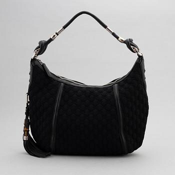 Gucci, a black neoprene handbag.