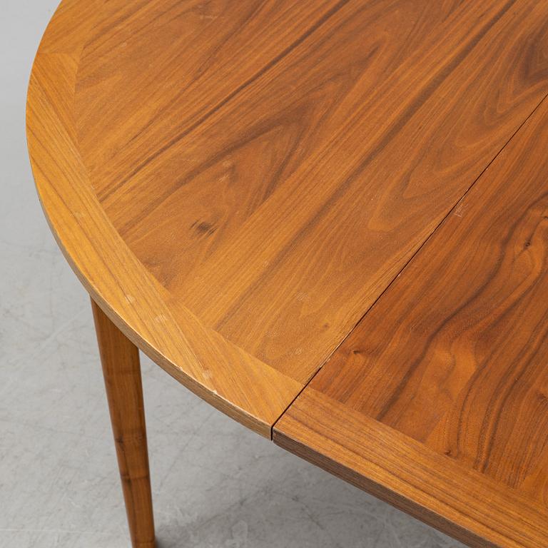 A round walnut veneered dining table.