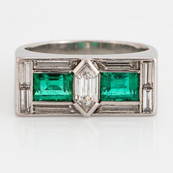 1084. A platinum ring set with faceted emeralds and diamonds.