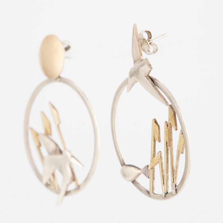 A pair of earrings featuring birds and fish, silver with gold detail.