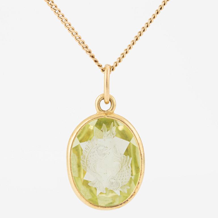 Pendant with yellow-green stone featuring the intaglio of the zodiac sign of Pisces, with a gold chain.