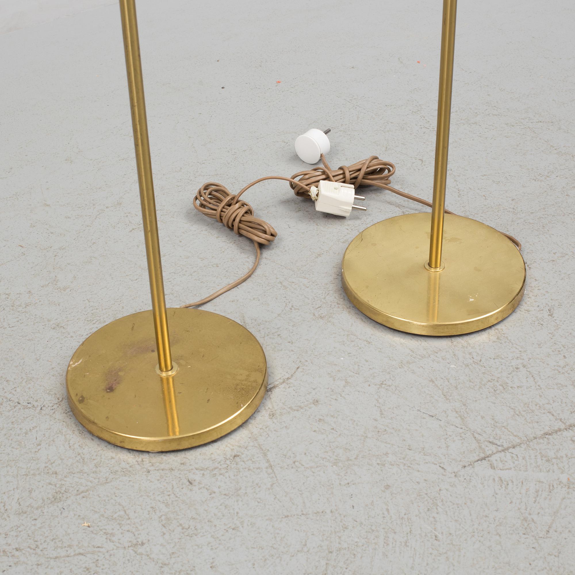 A pair of brass floor lamps, "MAE 27".