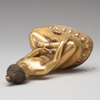 A gilt copper alloy figure of Akshobhya, Tibet, 16th Century.