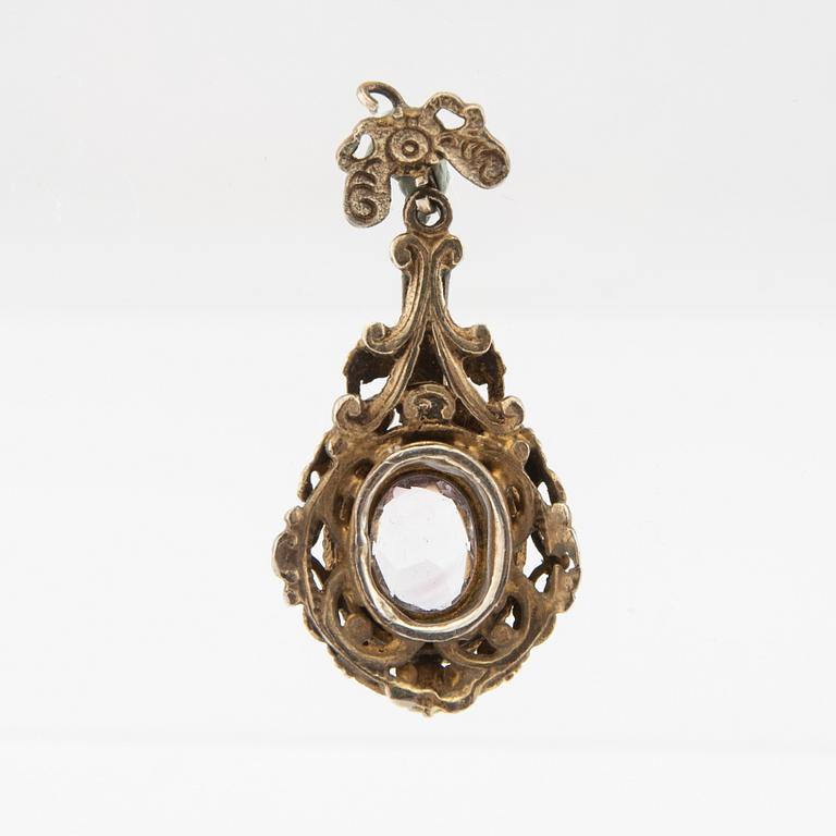 Pendant of gilded silver with an oval faceted amethyst, seed pearls, and enamel decoration, late 19th century.