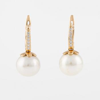 A pair of earrings with cultured freshwater pearls and round brilliant-cut diamonds.