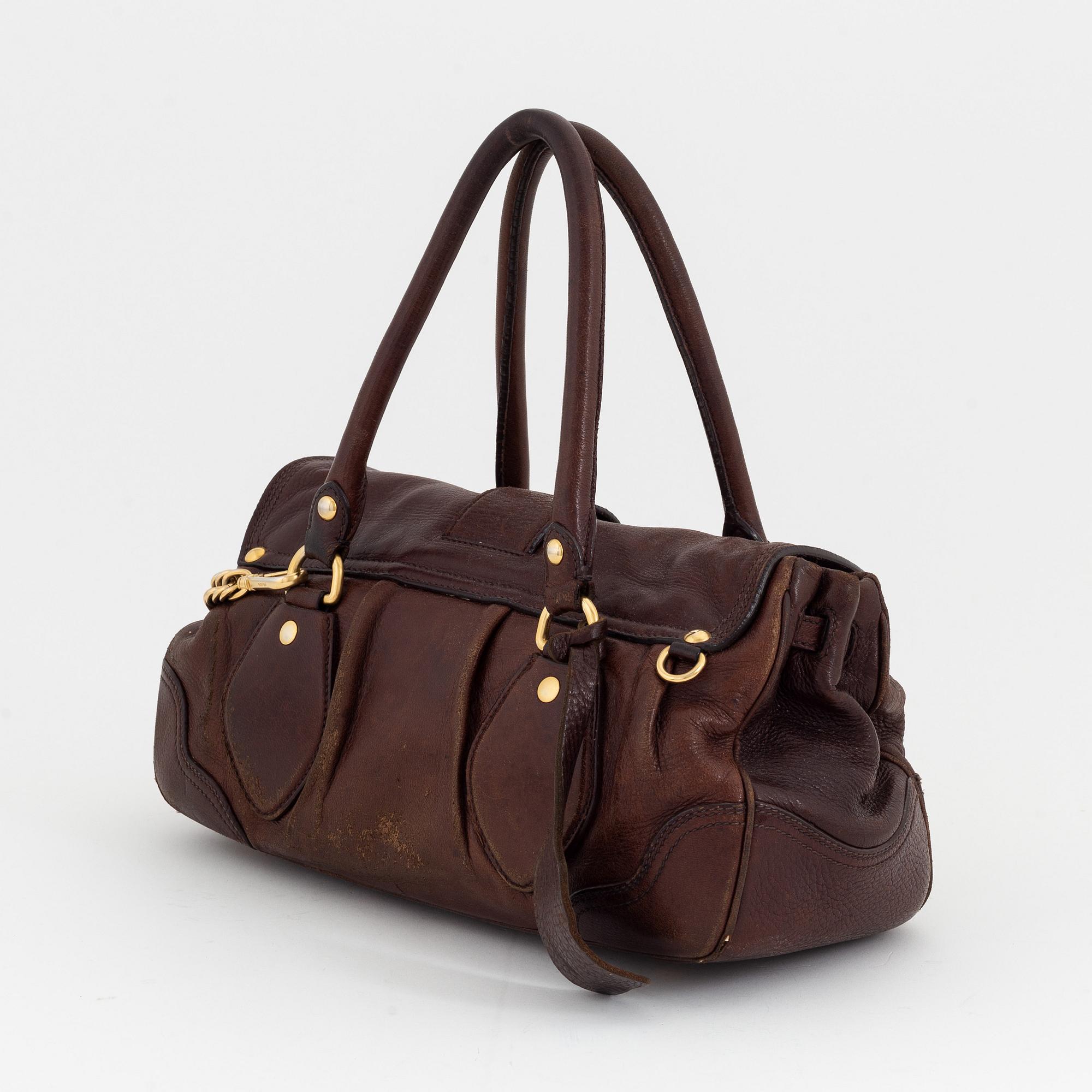 Prada, a brown leather bag.