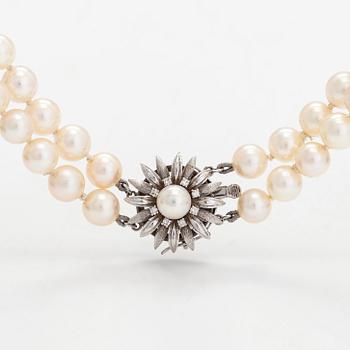 A double-stranded necklace, with cultured Akoya pearls, clasp in 14K white gold with brilliant-cut diamonds. With certif.