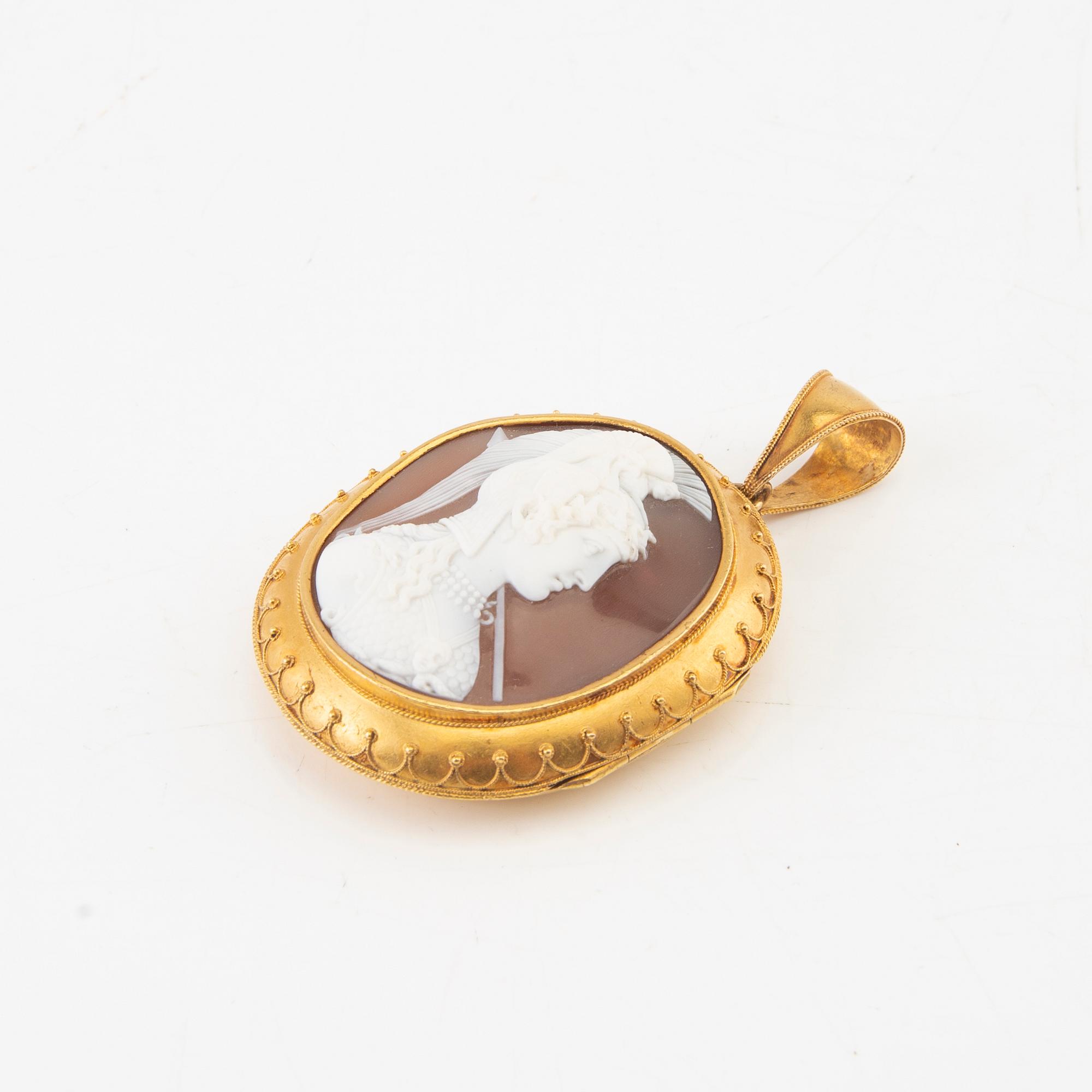 A 14K gold medallion with carved shell cameo.