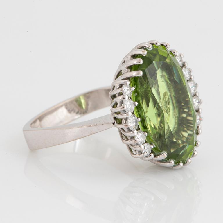 Cocktailring 18K vitguld med en fasettslipad peridot ca 11.00 ct samt runda briljantslipade diamanter.