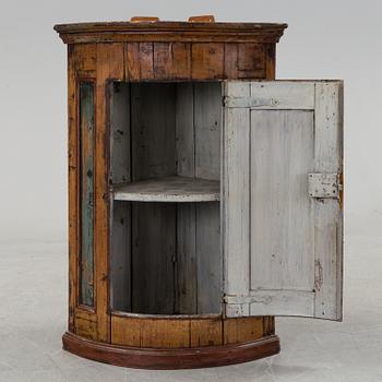 A painted folk art corner hanging cabinet, ca 1800.