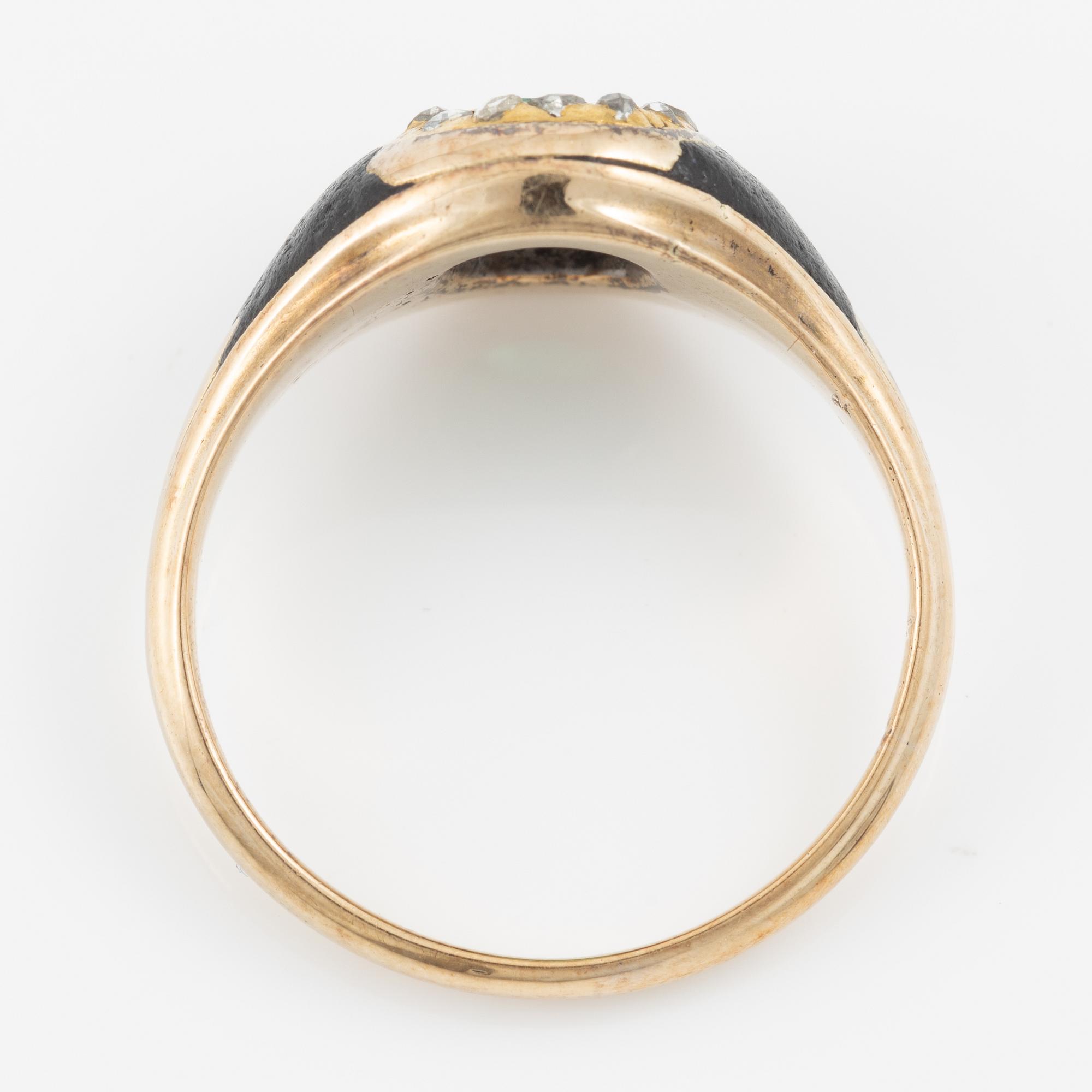 Ring, gold and black enamel with an emerald and rose-cut diamonds. Around the turn of the 20th century.