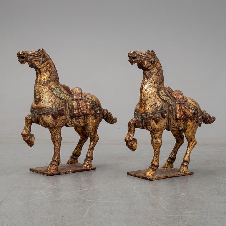 A pair of large Chinese wooden and gilt sculpture of horses, first half of the 20th century.
