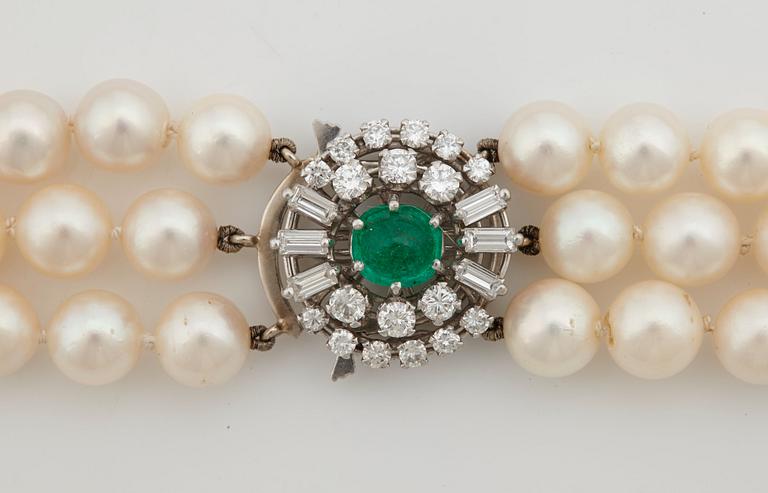 A three strand cultured pearl necklace, clasp with cabochon cut emerald circa 1.68 cts and diamonds.