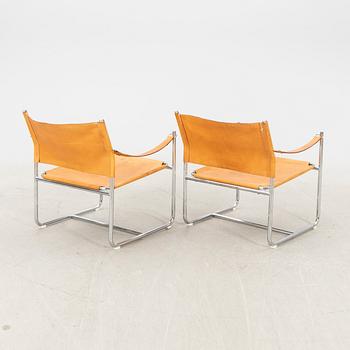 A pair of metal and leather arm chairs by DUX.
