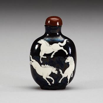 An enamelled porcelain snuff bottle with stopper, Qing dynasty.