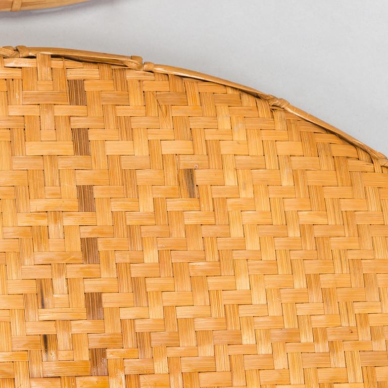 A mid-20th century rattan basket and two rattan trays. Retailer Artek Finland.
