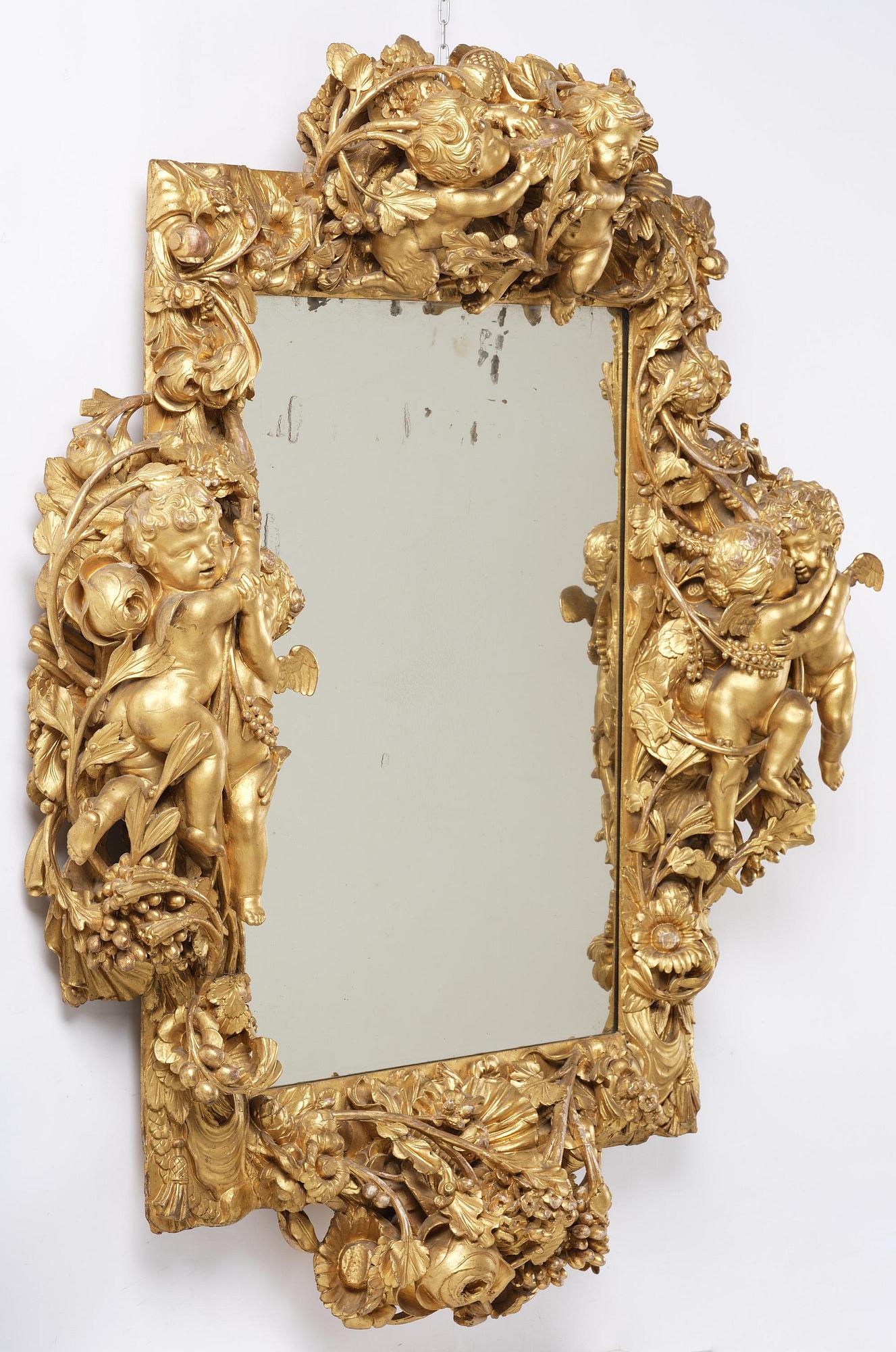 A presumably Dutch Louis XIV carved giltwood frame with mirror glass, in the style of Jean Le Pautre, late 17th century.