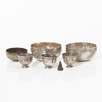 A group of three metal bowls and three stemcups and a small figure, Central Asia.