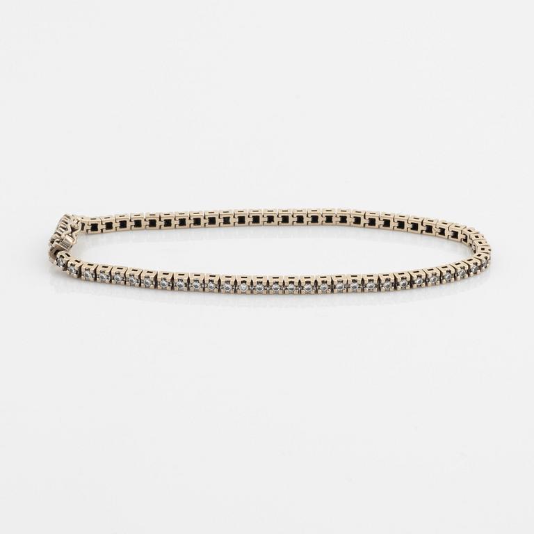 An 18K gold tennis bracelet set with round brilliant-cut diamonds.