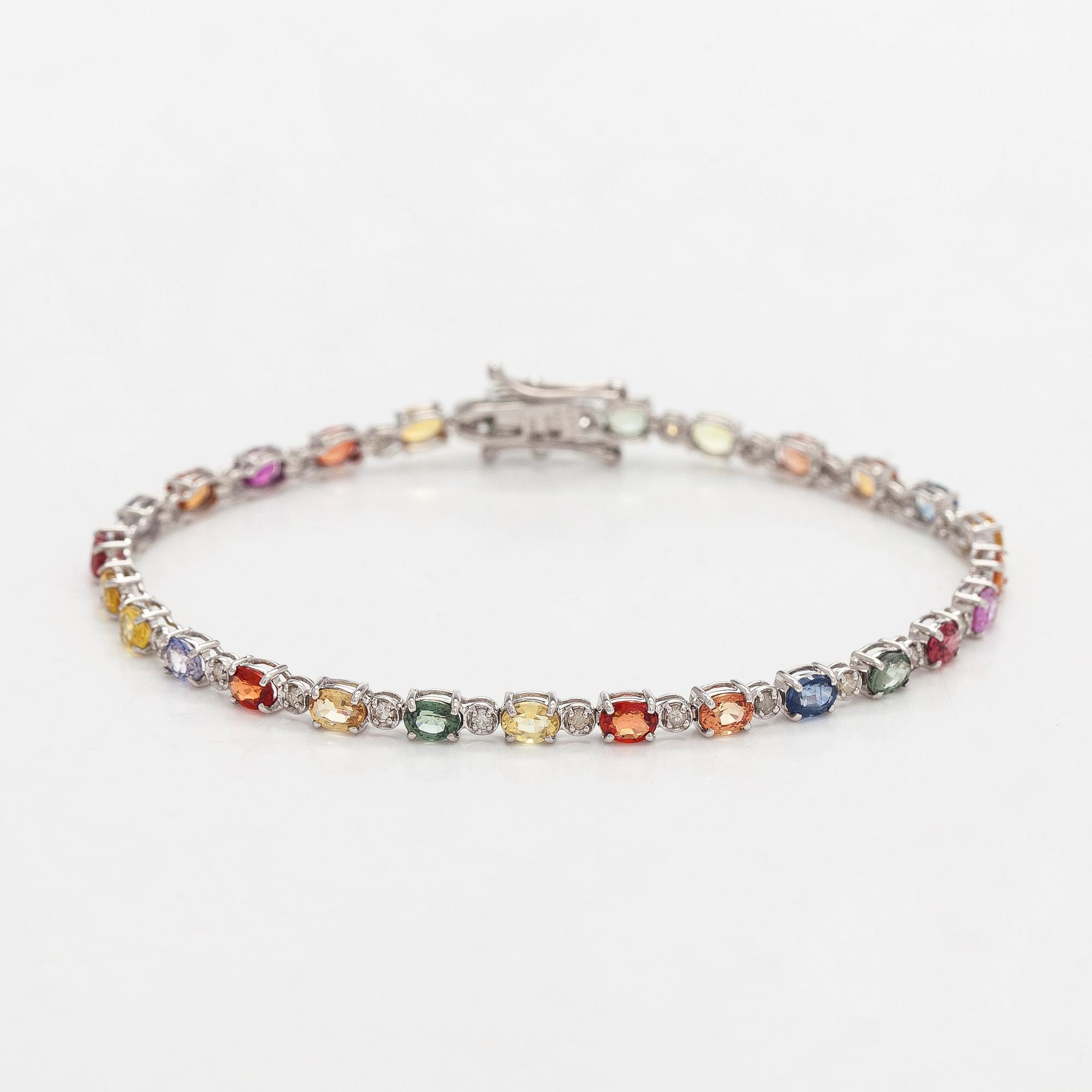 Rannekoru, 18K valkokultaa monivärisillä safiireilla ja timanteilla.