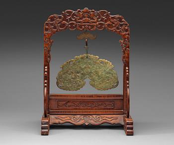 29. A pale spinach nephrite chime-stone with wooden stand, Qing dynasty, presumably 19th Century.