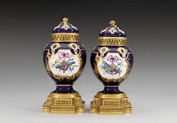 A pair of gilt bronze mounted Sevres pot-pourri jars with covers, 18th Century. (2).