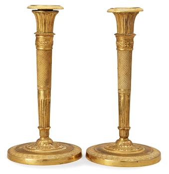 682. A pair of French Empire early 19th century candlesticks.