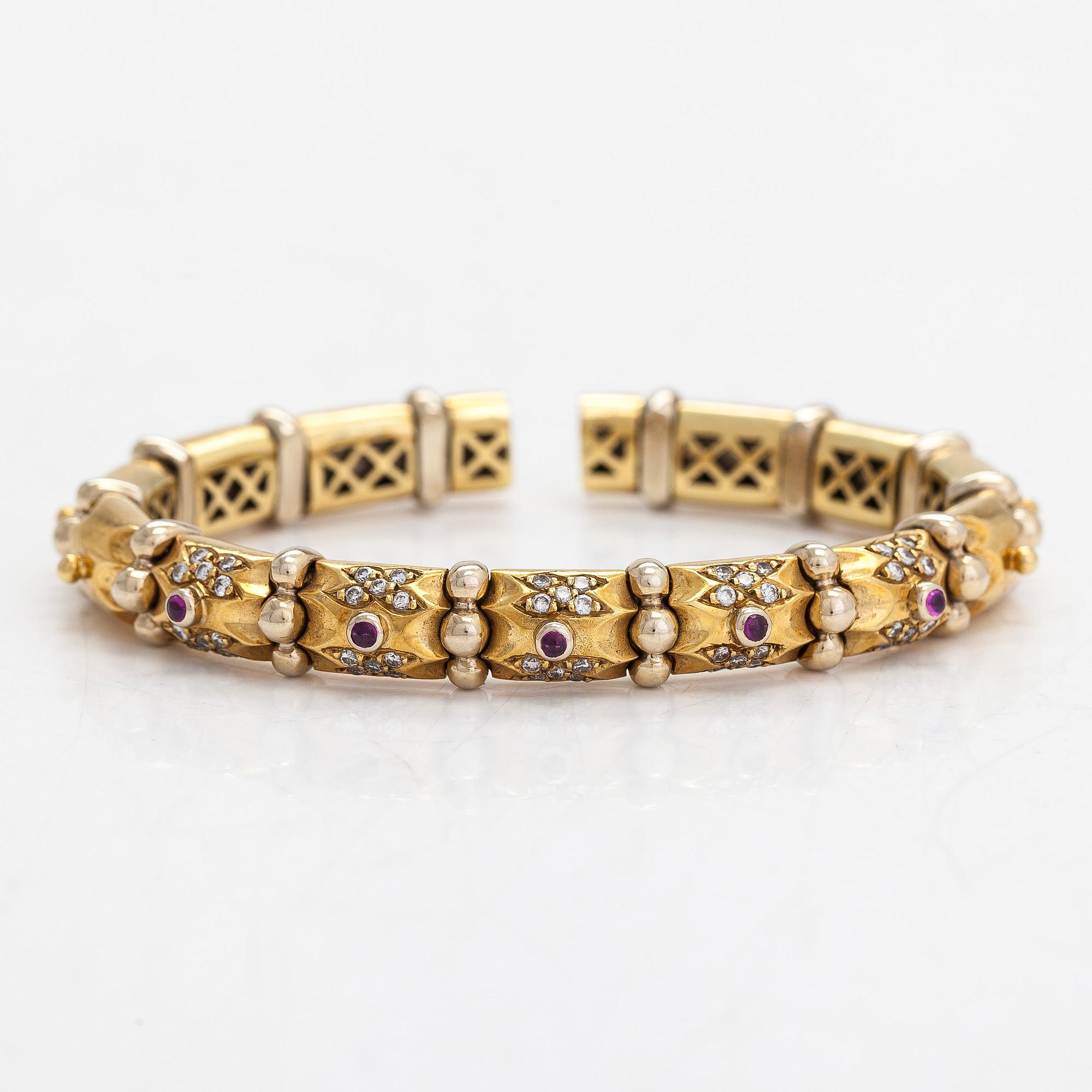 An ca. 18K gold bangle with diamonds approx. 0.50 ct. in total and rubies.