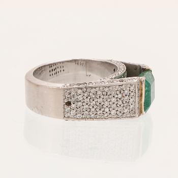 A 9K white gold ring with an emerald and brilliant cut diamonds.