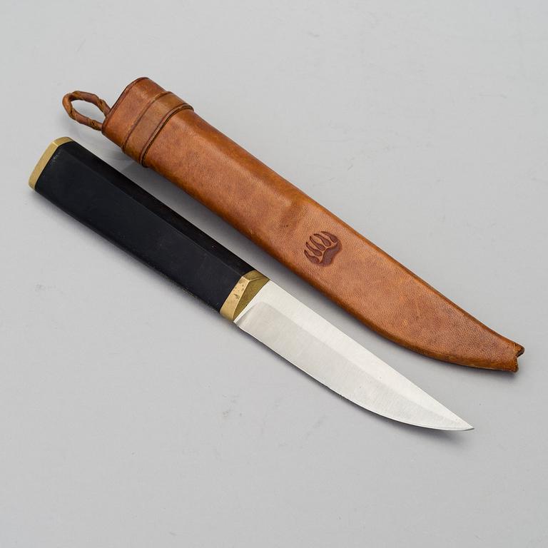 A Finnish puukko knife in stainless steel, nylon and brass designed by Tapio Wirkkala, Hackman Finland.