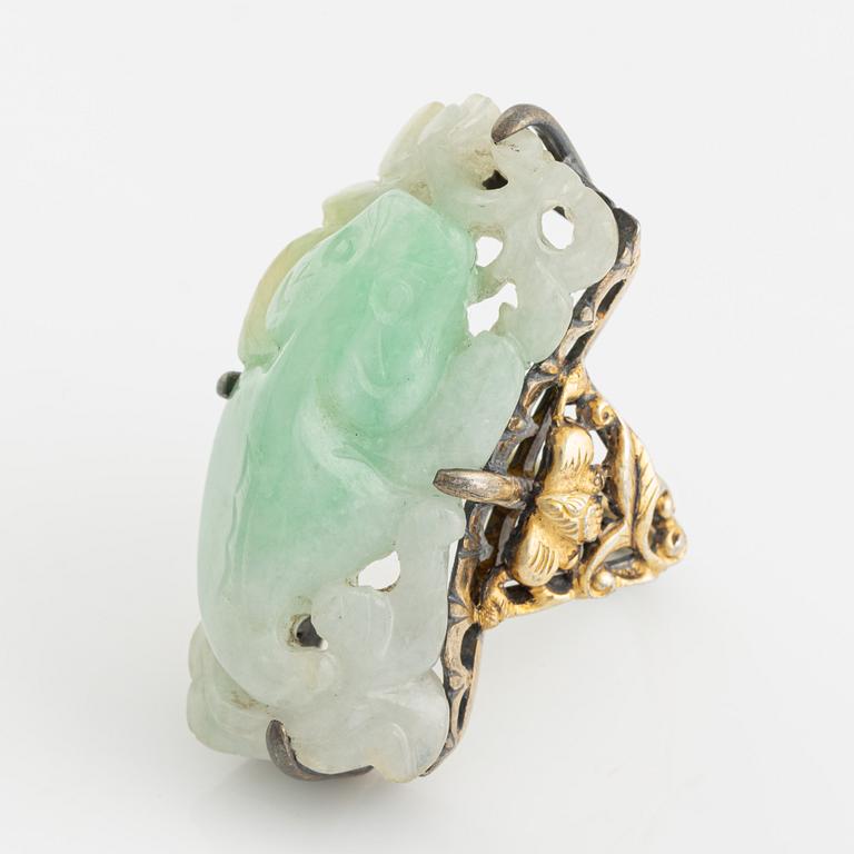 Ring in yellow metal with a white/green stone, possibly nephrite.".