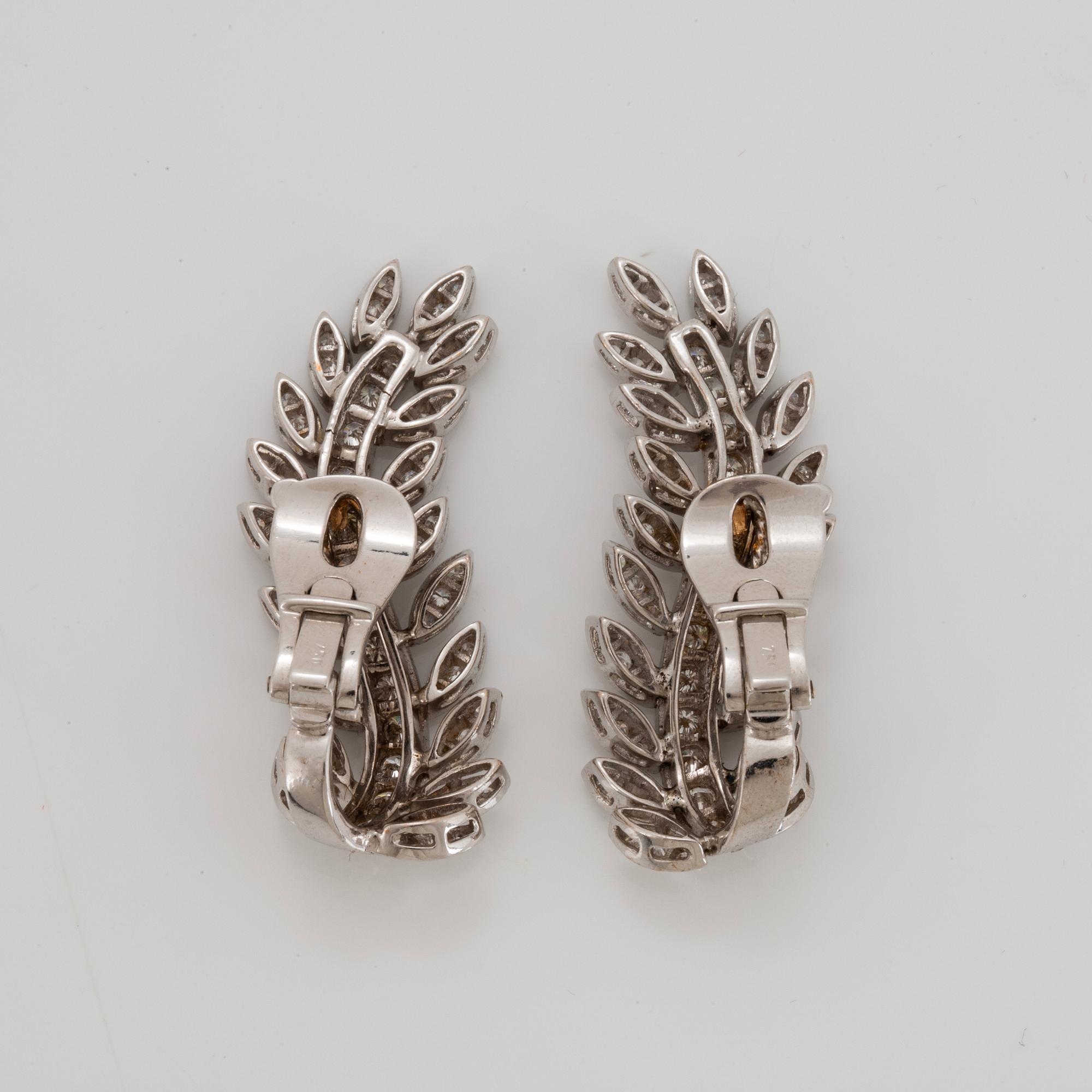 A pair of 18K white gold earrings set with round brilliant-cut diamonds.