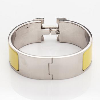 Hermès, A "Click H" bracelet made of metal and yellow enamel. Marked Hermès, ST1105, S, Made in France.