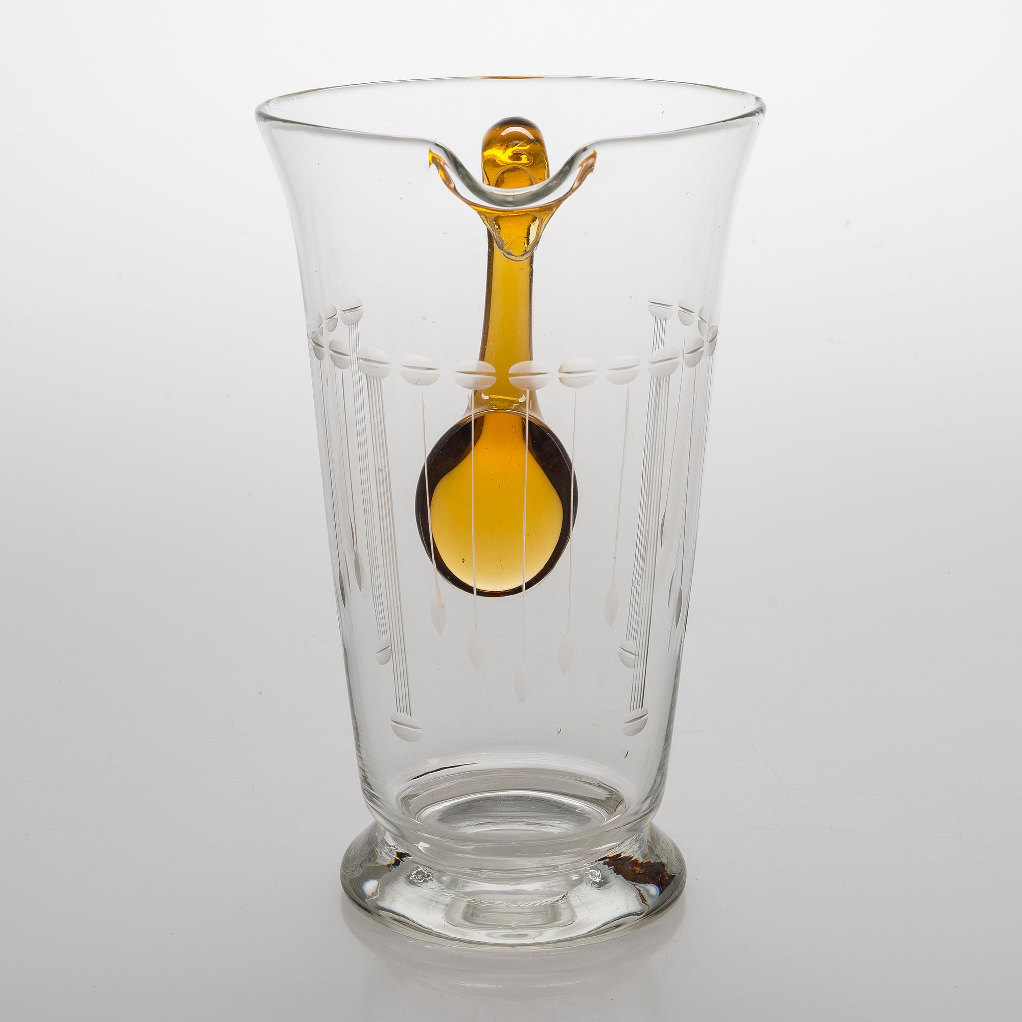 A glass pitcher with six glasses from around the 1920s.