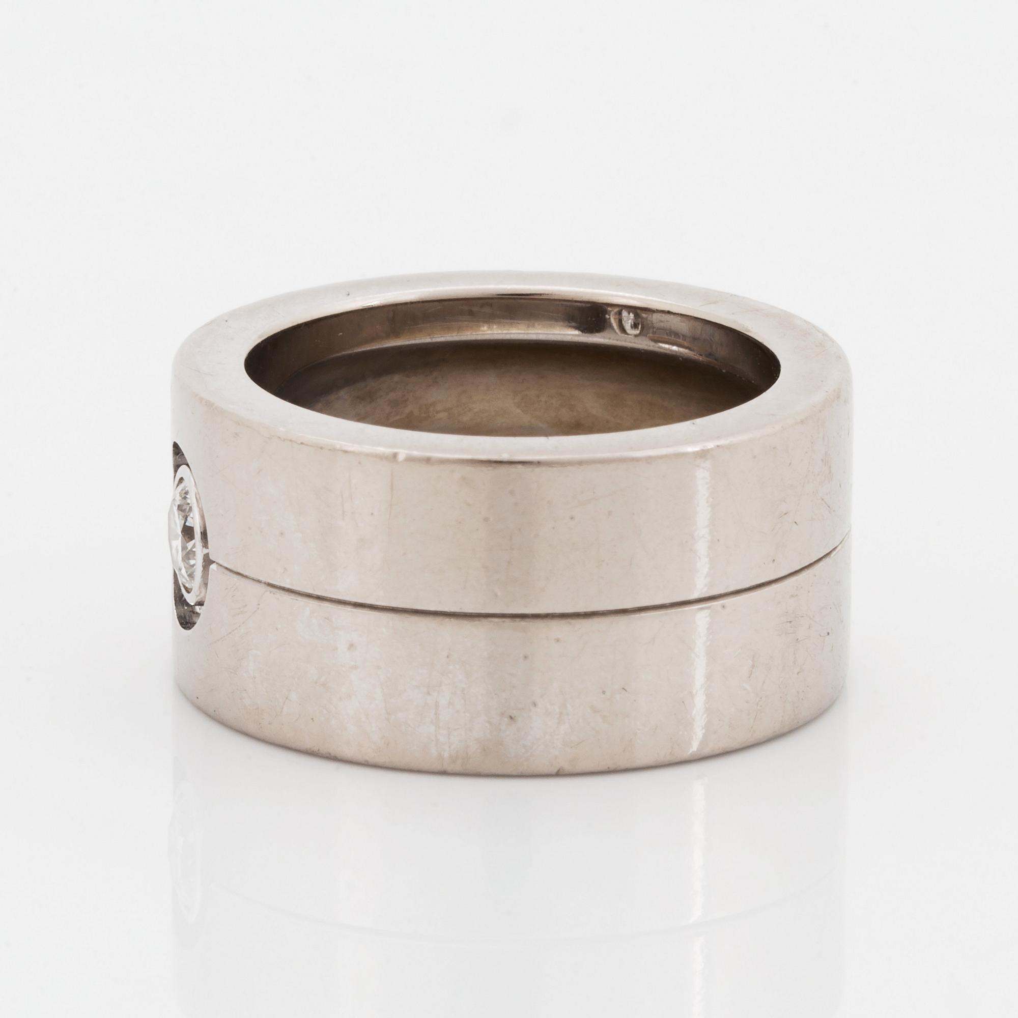 A Cartier 18K white gold ring set with a round brilliant-cut diamond.
