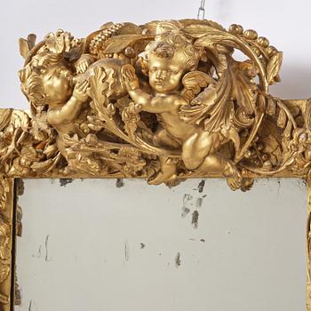 A presumably Dutch Louis XIV carved giltwood frame with mirror glass, in the style of Jean Le Pautre, late 17th century.