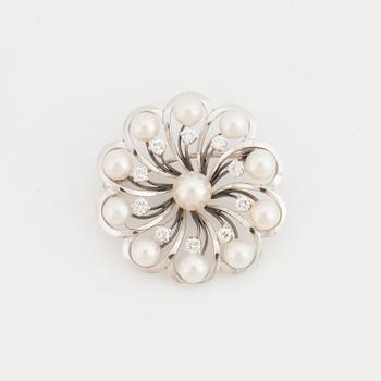 A brooch set with cultured pearls and round, brilliant-cut diamonds.