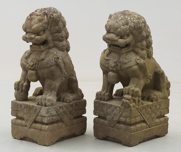 A pair of stone figures of Buddhist Lions on stands, late Qing dynasty / early 20th century..