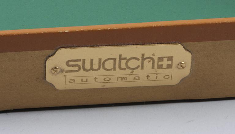 OLIKA KONSTNÄRER, objekt innehållande 5 signerade serigrafier samt Swatch Automativ Gran Via armbandsur.