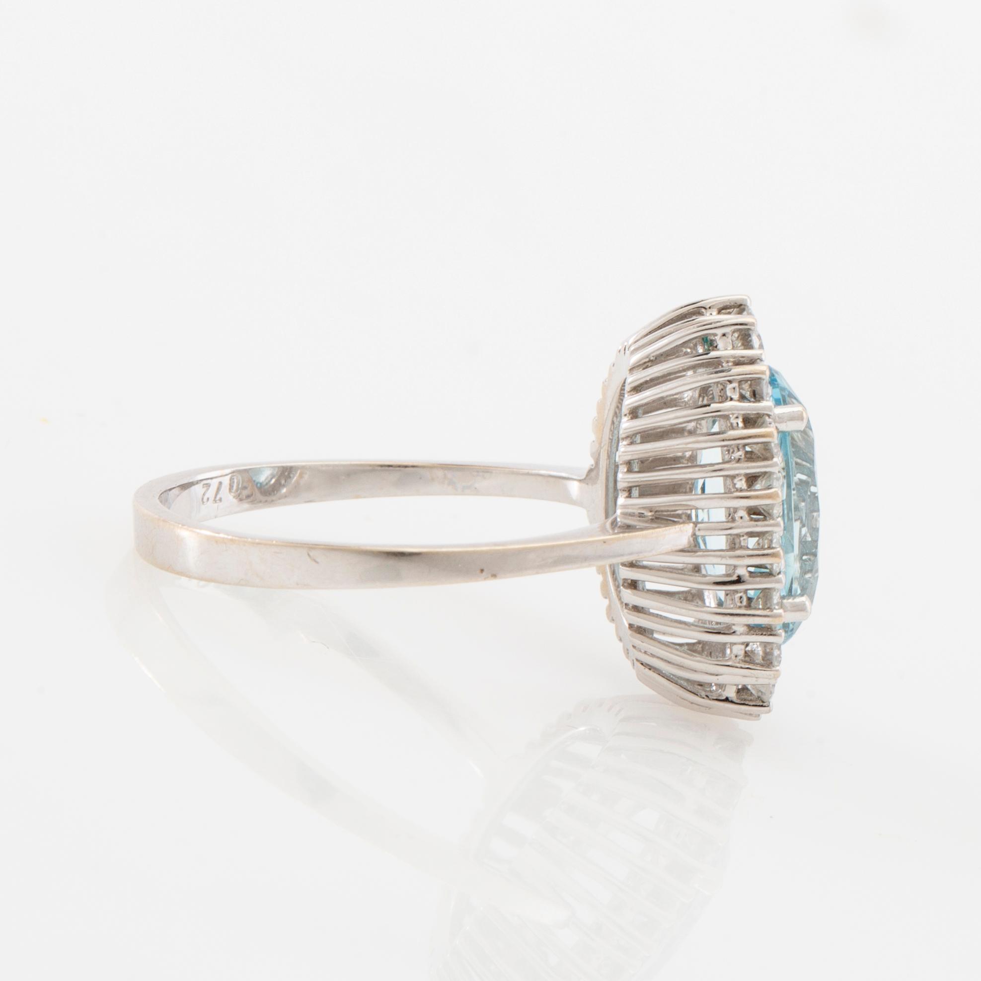 Ring 18K white gold set with an oval faceted aquamarine and round brilliant-cut diamonds.