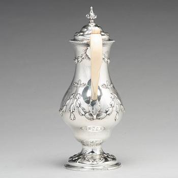 An English 18th century silver hot water-jug, mark of Chas Woodward, London 1773.