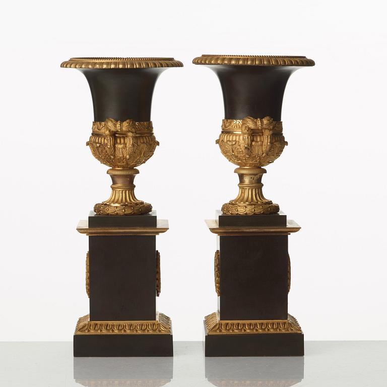 A pair of French Empire early 19th century gilt and patinated bronze urns.