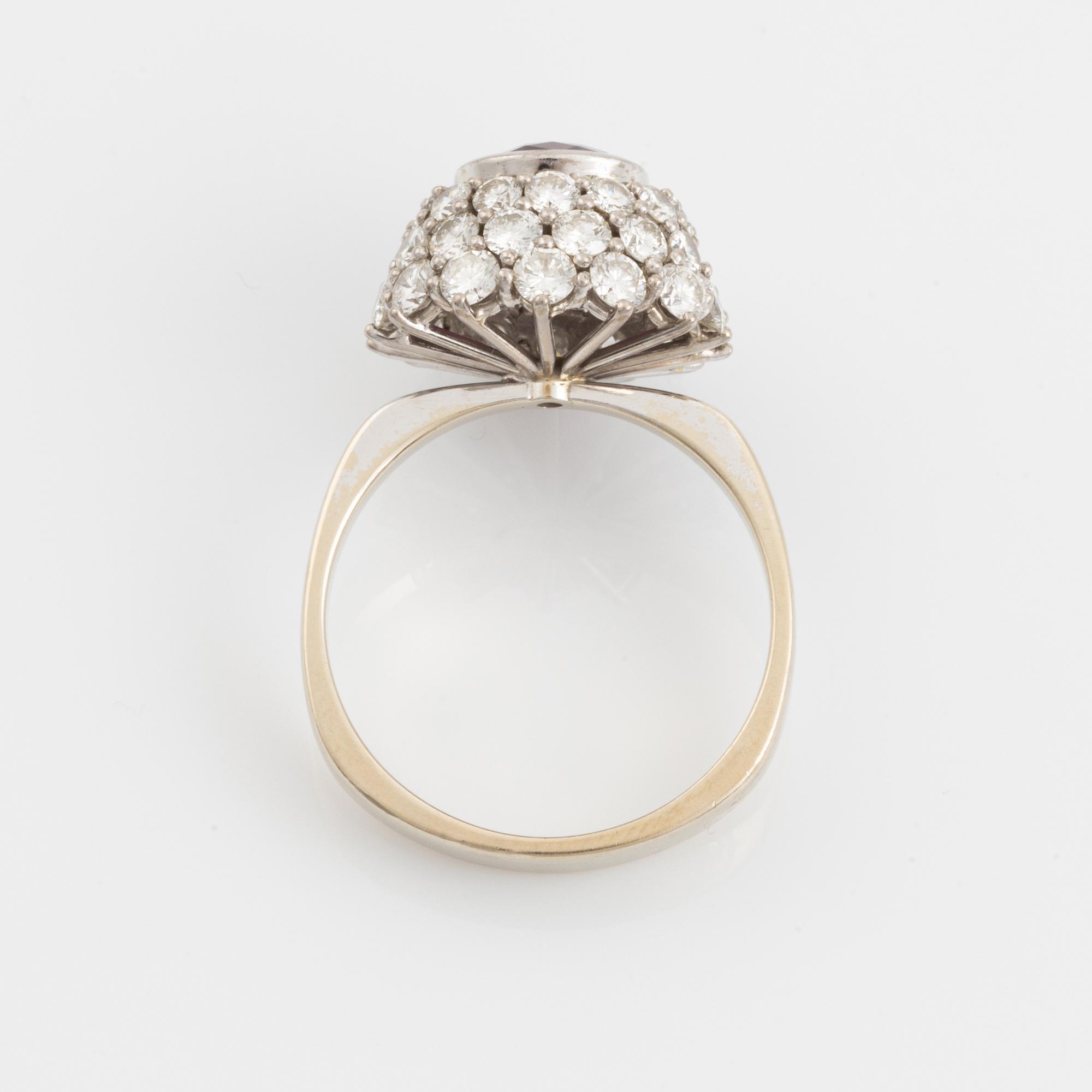 Ring 18K guld med en fasettslipad rubin samt runda briljantslipade diamanter.