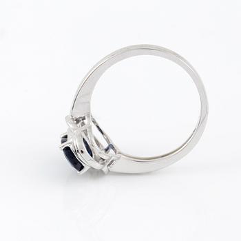 RING, 14K vitguld med ovalslipad safir tot ca 1,24 cts omgivs av 16 åttkantslipade diamanter. Vikt 3,47 g.