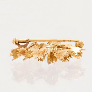 An 18K gold brooch set with a cultured pearl.