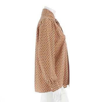 YVES SAINT LAURENT, a beige and black polka dotted blouse.