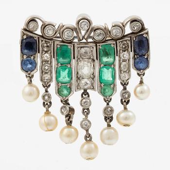 Brooch in platinum set with old-cut diamonds, sapphires, emeralds, and pearls.