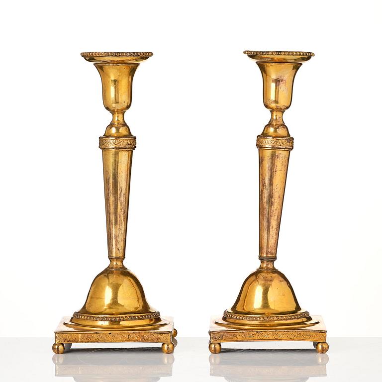 A pair of late George III gilt-copper candlesticks, early 19th century.