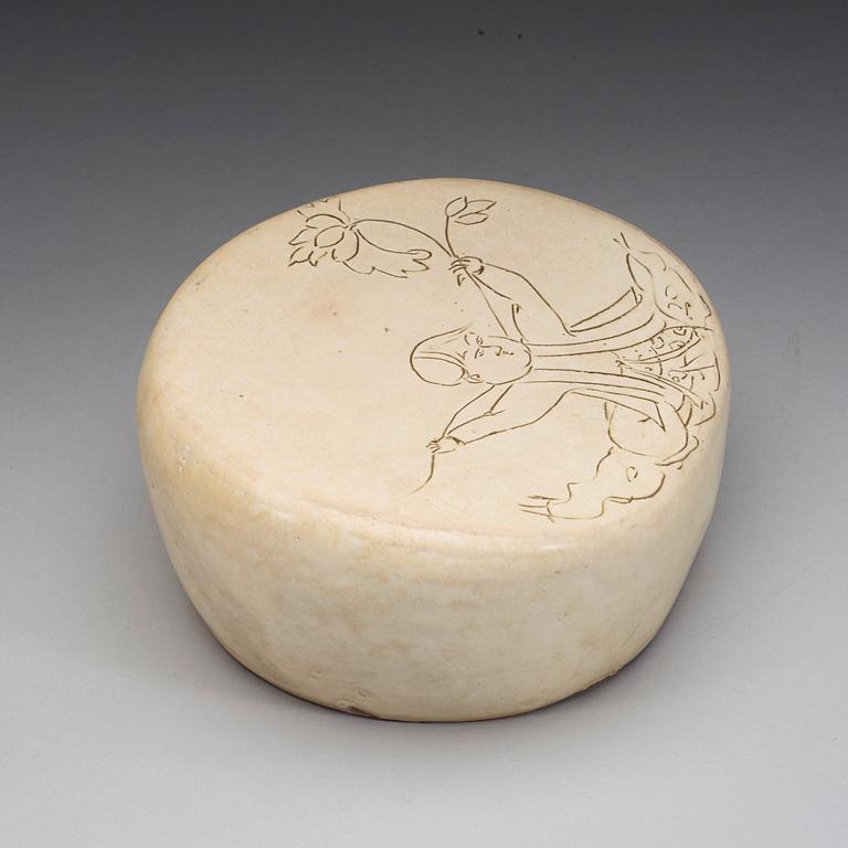 A potted white glazed pillow with incised decor of a boy, presumably Liao or Song Dynasty (907-1279).